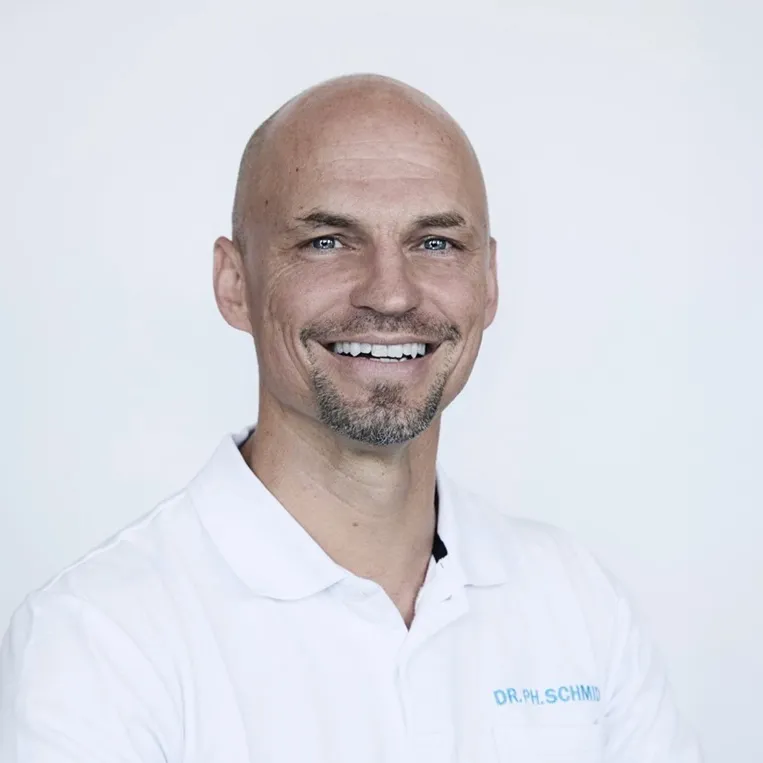 Er trägt ein Polo-Shirt und lächelt offen in die Kamera.