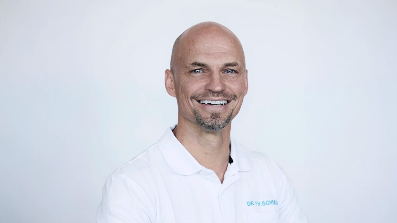 Er trägt ein Polo-Shirt und lächelt offen in die Kamera.