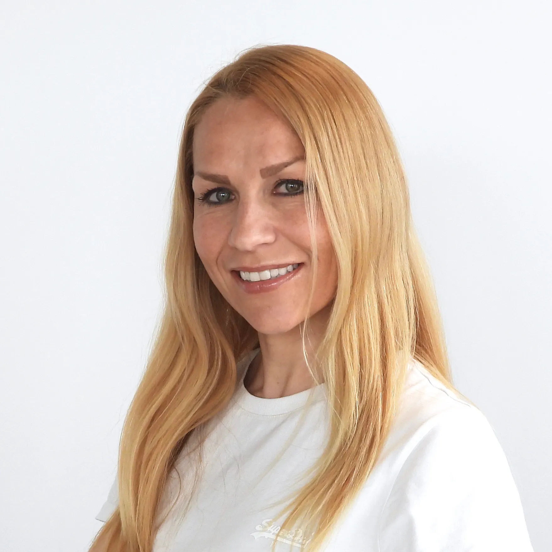 Sie lächelt sympathisch und hat lange, glatte, blonde Haare.